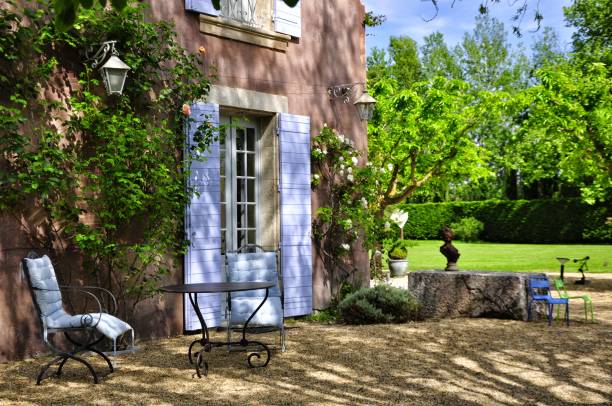 Devant maison avec arbres et volets bleus